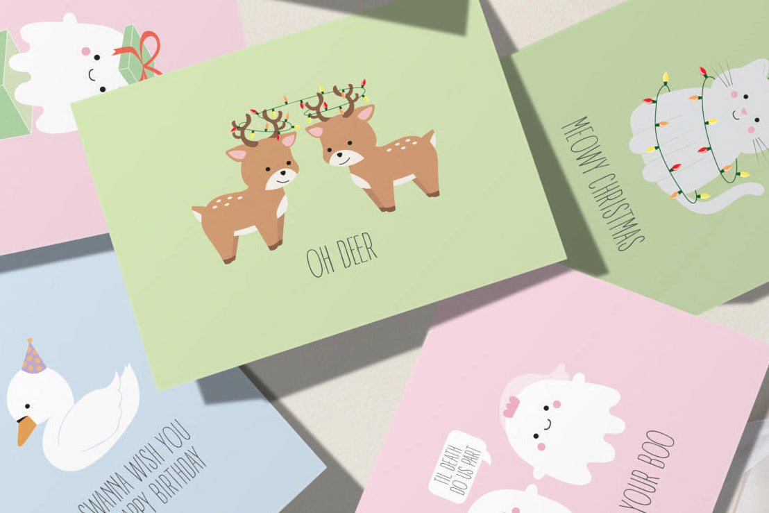 Collection of colorful greeting cards with various designs on a light wooden surface.
